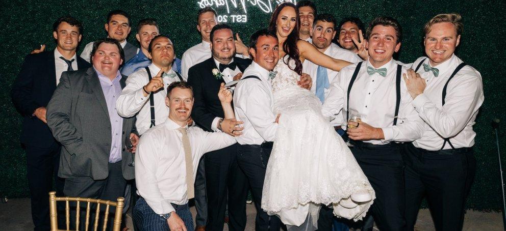 A dozen people lift the bride in her gown